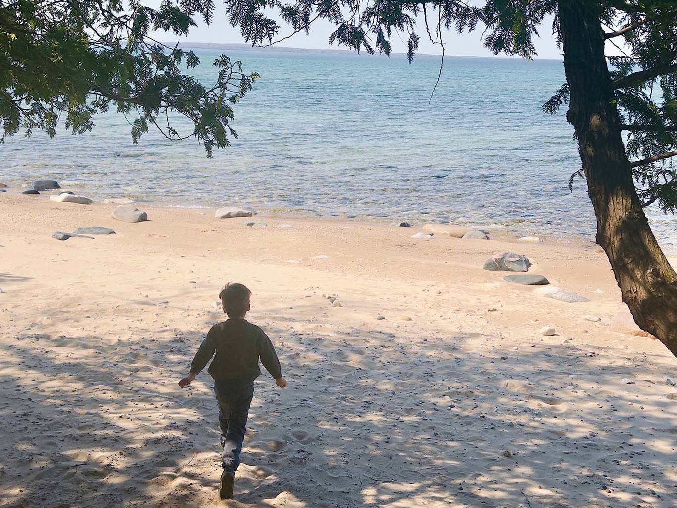 A child on the beach at the Thorn Swift Nature Preserve