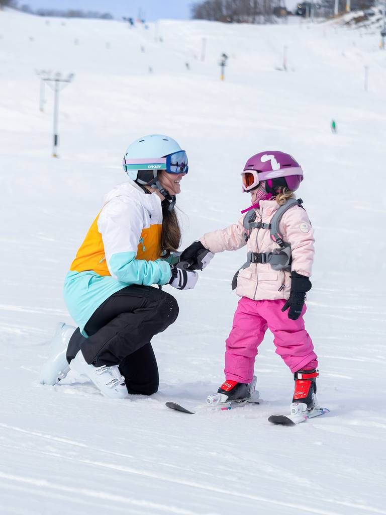 A mom and daughter in ski gear