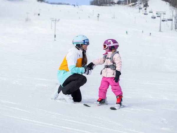 A mom and daughter in ski gear