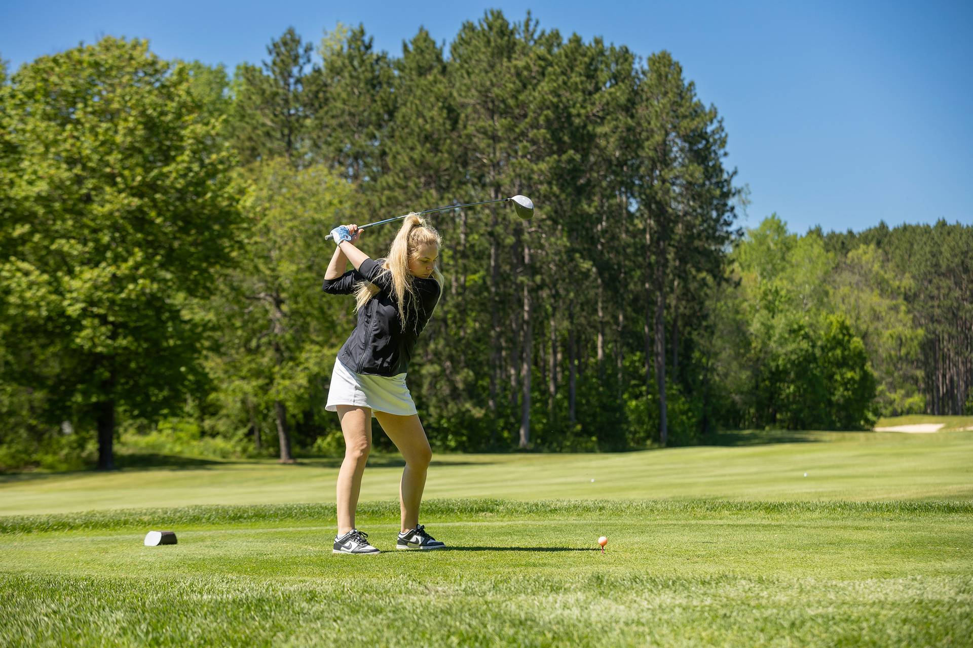 A woman golfing at The Highlands