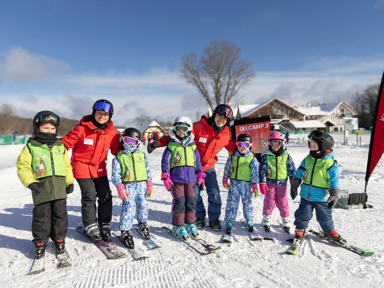 A group of ski instructors and kids smiling and posing for Ski Camp